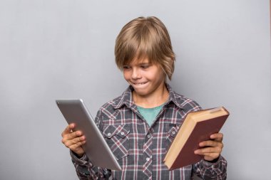 Çocuk kitabı ve tablet tutar 