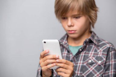 Cep telefonu kullanarak sevimli genç çocuk