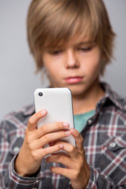 Cep telefonu kullanarak sevimli genç çocuk