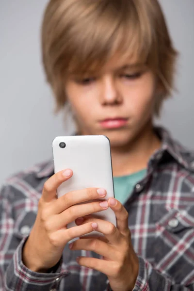 Милий хлопчик-підліток використовує мобільний телефон — стокове фото