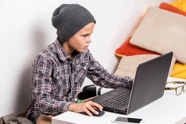 Lindo chico trabajando en el portátil en su habitación — Foto de Stock