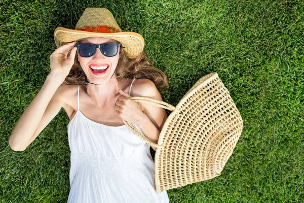 Mujer joven feliz acostada sobre hierba verde riendo con emoción —  Fotos de Stock
