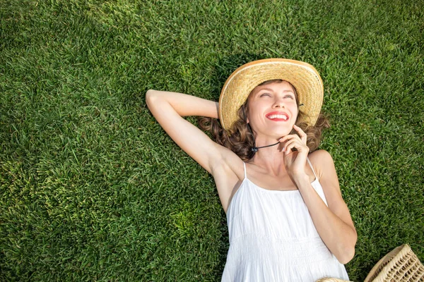 Mujer joven feliz acostada sobre hierba verde — Foto de Stock