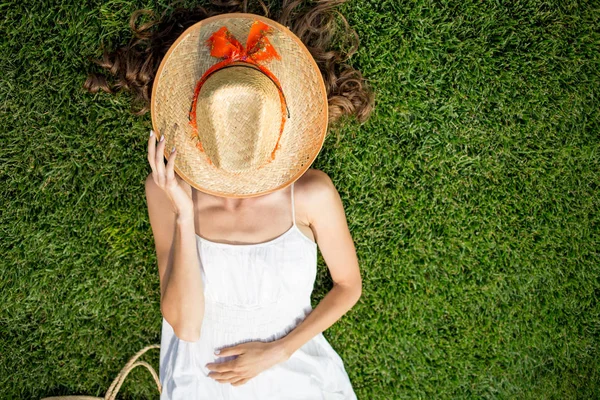 Mujer joven disfrutando de la libertad sintiéndose feliz mientras está acostada en la hierba — Foto de Stock