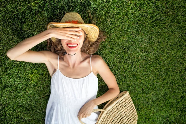 Mujer joven feliz acostada sobre hierba verde — Foto de Stock