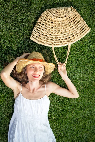Щаслива молода жінка лежить на зеленій траві — стокове фото