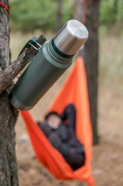 Thermos hanging on a tree during relaxation in a forest — Stock Photo, Image