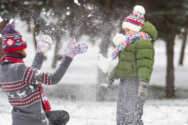 Familia feliz al aire libre jugando con copos de nieve —  Fotos de Stock