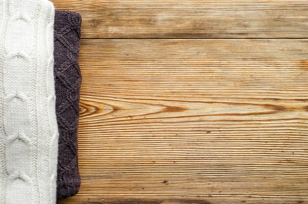 Stos z dzianiny zimowych lub jesienne ubrania na podłoże drewniane — Zdjęcie stockowe