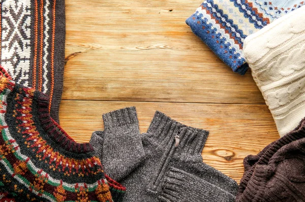 Cup of autumn tea with heap of folded wool sweaters and autumn leaves — Stock Photo, Image