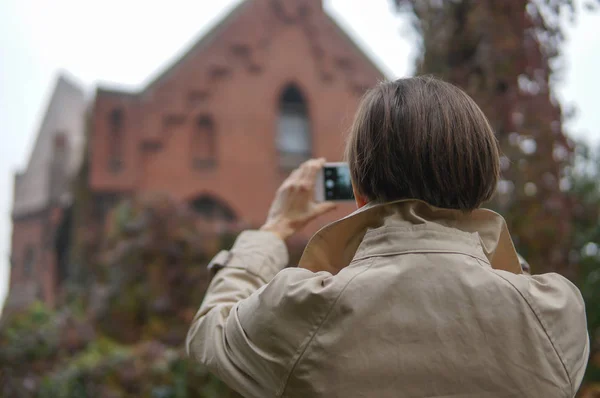 Frau beim Spazierengehen in der Stadt mit ihrem Handy beschäftigt — Stockfoto