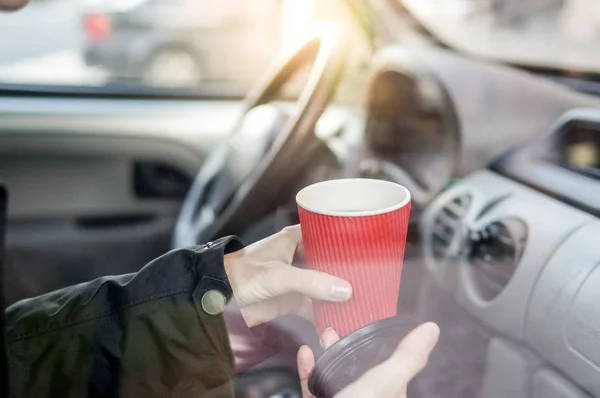 Женщина пьет кофе в машине — стоковое фото