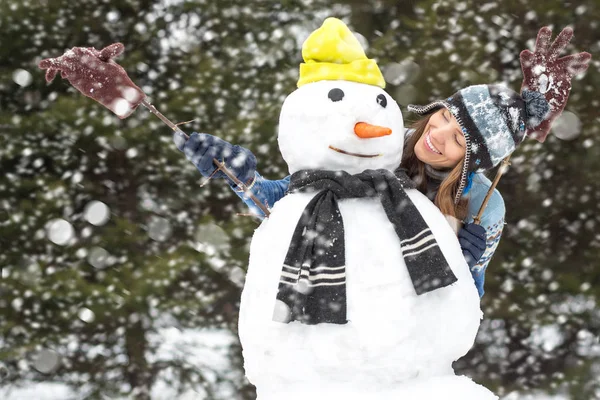 冬天乐趣 冬天休闲和冬天假期 年轻妇女有乐趣做雪人与下落的雪 — 图库照片