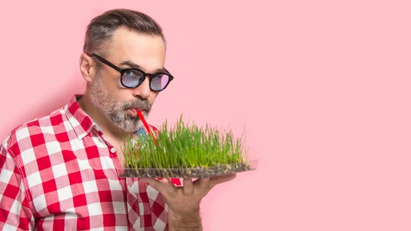 Przystojny Mężczyzna Pitnej Homegrown Wheatgrass Napój Koncepcja Różowym Tle — Zdjęcie stockowe