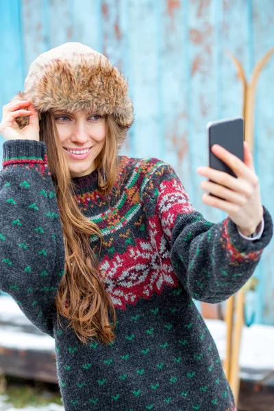 Schöne Winterfrau Mit Smartphone Pullover Und Pelzmütze Über Grunge Holzwand — Stockfoto