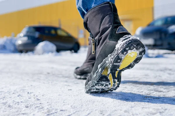 男性或女性冬季穿的皮靴在白雪皑皑的雪道上行走 — 图库照片