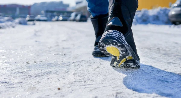 男性或女性冬季穿的皮靴在白雪皑皑的雪道上行走 — 图库照片
