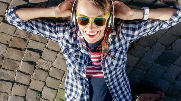 Jonge Vrouw Liggend Straatstenen Genietend Van Zon Luisterend Naar Muziek — Stockfoto