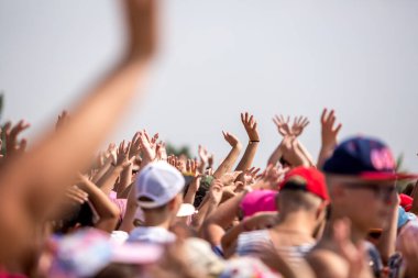 Mariupol, Ukrayna - 25 Haziran 2019: Deniz kenarında elleri havada mutlu genç insanlar grubu