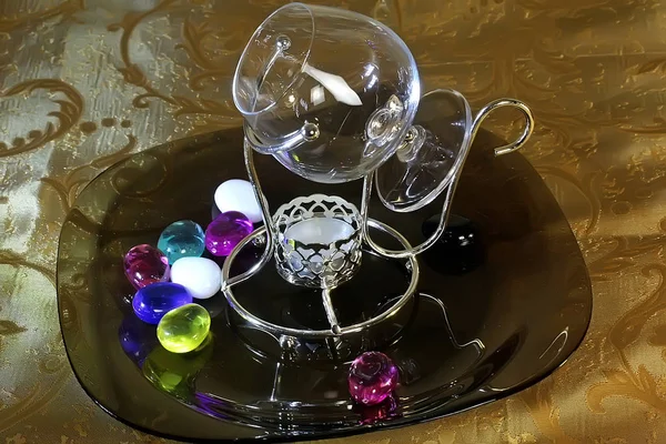 一套玻璃和水晶盘 不同颜色的绿色 透明的酒杯和烛台 有彩色玻璃球 餐巾和框架在桌上 — 图库照片