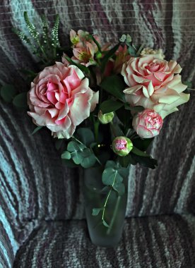 Bir buket gül ve beyaz çiçekler, parlak yeşil yapraklı muhteşem pembe ve beyaz güller, açılmamış çiçeklerin narin tomurcukları ve güller