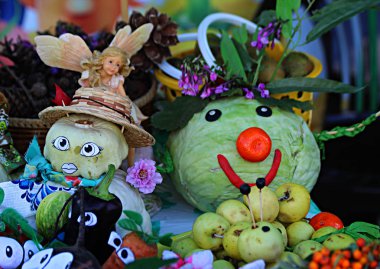 Sebze, lahana, soğan, mısır, kereviz, salatalık ve meyve elmaları, masada ve sepette muzlar.