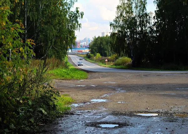 Vedlejší Silnice Auty Jedoucími Města Stávajícími Stromy Rostlinami Různých Plevelů — Stock fotografie