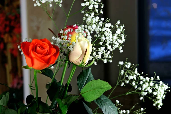 Interior and flowers in a vase with a bouquet and one rose yellow, white, red, pink and Burgundy in a glass vase on the table