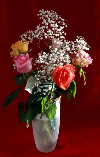 Interior and flowers in a vase with a bouquet and one rose yellow, white, red, pink and Burgundy in a glass vase on the table