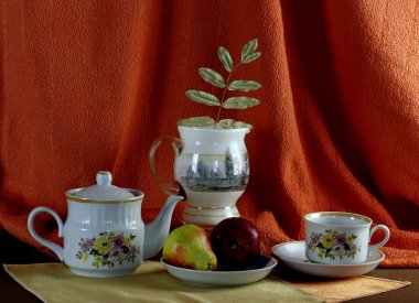 Düz yaşam için iç malzemeler: saat, meyve, şarap bardakları, çay seti, sürahi, mum, bilgisayar, şişe ve sehpa