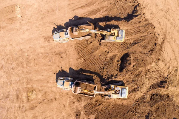 掘削機 関節式運搬車などの複数の重工業車両が動作する広大な掘削現場の空中像 — ストック写真