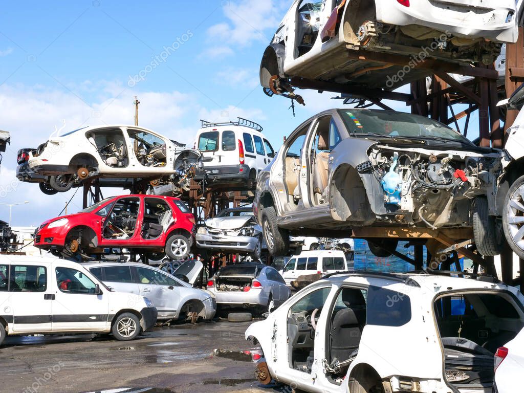 Scrap yard with crushed cars and blue sky