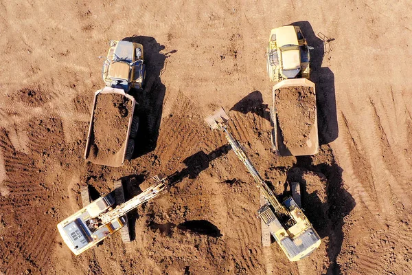 Excavadoras que cargan tierra sobre un camión de transporte articulado . — Foto de Stock