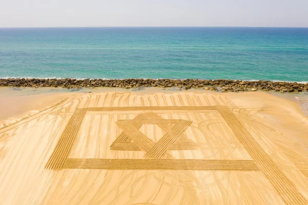 コロナウイルスのロックダウン中の独立記念日のためにビーチサンドで設計されたイスラエルの旗. — ストック写真