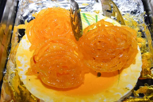 Sıcak Jalebi Hint düğününde bir tabakta saklandı.