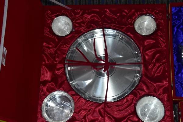 Kırmızı bir mücevher kutusunda gümüş eşyalar.