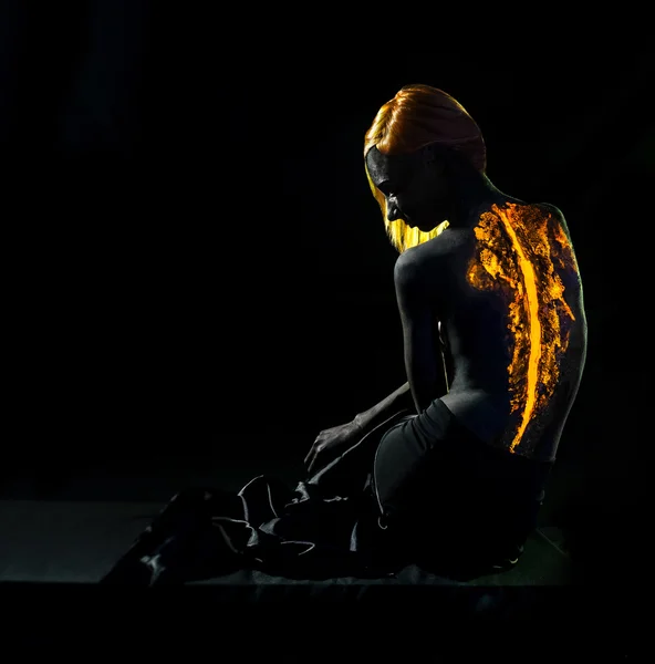 Pelirroja con llamas sentada en la oscuridad — Foto de Stock