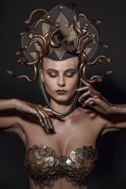 girl Medusa headdress of gold color on a black background clipart