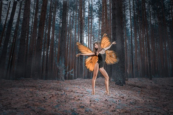 Tjej vs röd fjärilsvingar i en svart bodysuit skog — Stockfoto