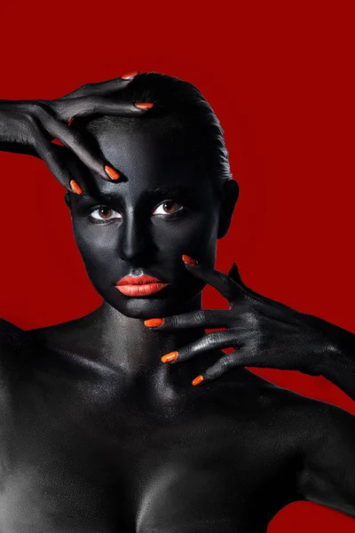 Chica con piel negra y labios rojos sobre un fondo rojo — Foto de Stock