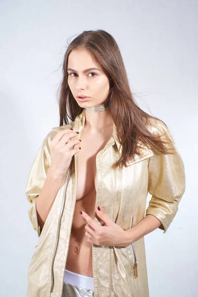 Stüdyoda altın ceketli ve gümüş pantolonlu güzel bir kız var. — Stok fotoğraf