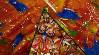 Genç ve güzel bir kadının vücudunda parlak renkli boya.