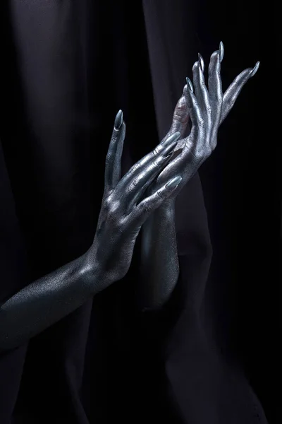Две красивые руки мужчины в серебряной краске на черном фоне — стоковое фото
