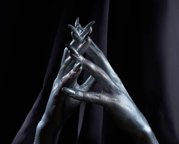 Две красивые руки мужчины в серебряной краске на черном фоне — стоковое фото