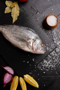 Limon dilimleri, domatesler ve körfez yapraklı lezzetli taze balık manzarası.