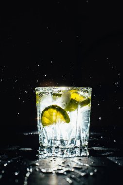 Siyah arka planda lezzetli soğuk limonatalı cam.