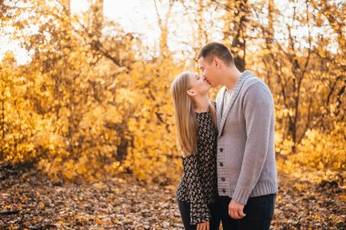 # Güzel, mutlu genç bir çift # # Sonbahar ormanında bir arada öpüşüyor #