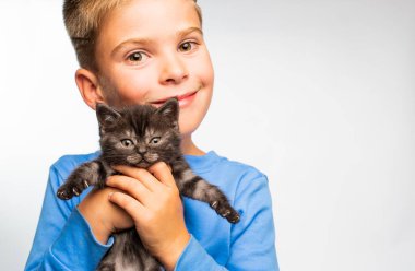 Sevimli mutlu çocuk kucağında sevimli bir kedi yavrusu