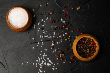 Siyah arka planda tuzlu ve biberli kaselerin yakın plan görüntüsü