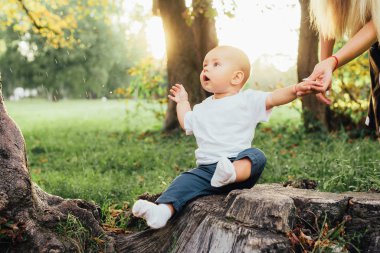 Küçük çocuk parkta annesiyle oynuyor.